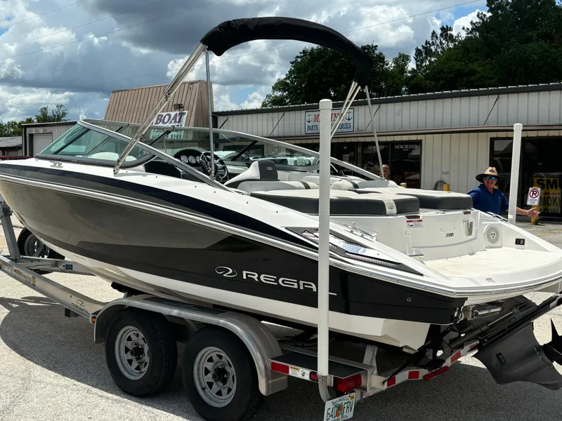 Slide: The Image of 2016 Regal 2100 RX Bowrider on trailer, parked outside a boat dealership. - 5