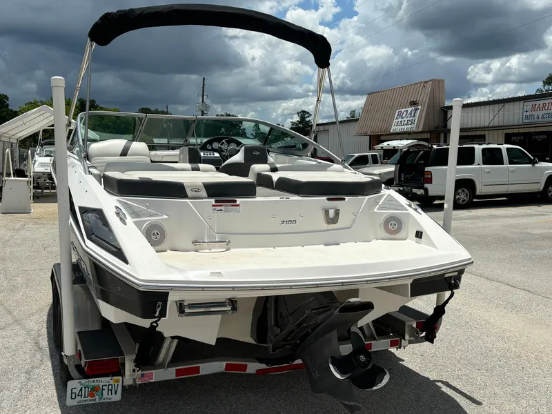 Slide: The Image of 2016 Regal 2100 RX Bowrider boat on trailer, parked outdoors under cloudy sky. - 6