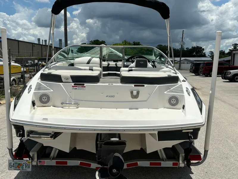 Slide: The Image of 2016 Regal 2100 RX Bowrider boat on trailer, rear view, under cloudy sky. - 7