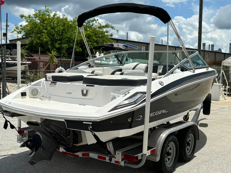 Slide: The Image of 2016 Regal 2100 RX Bowrider on trailer, sleek design, outdoor setting. - 8