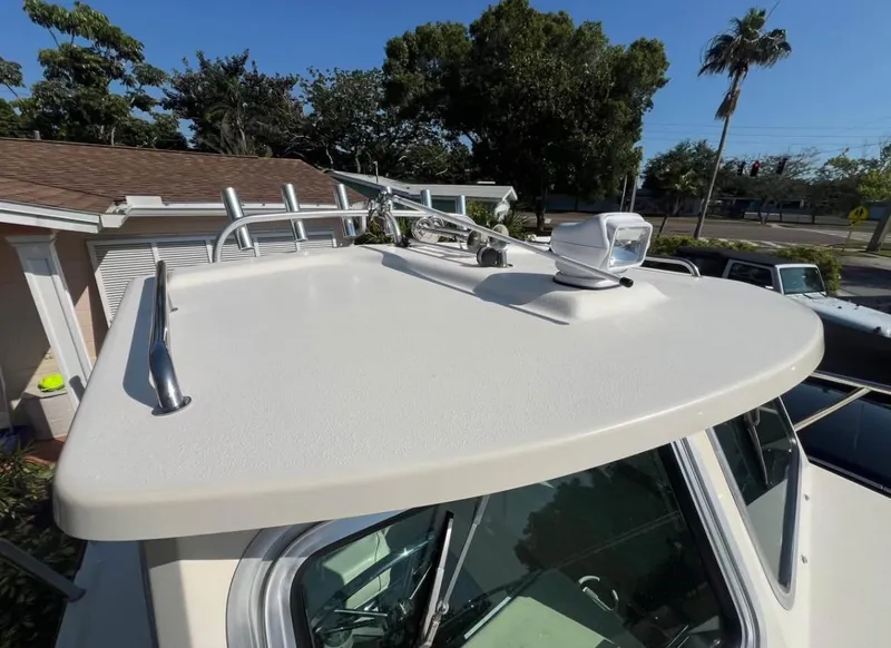 Slide: The Image of 2008 Parker 2120 Sport Cabin boat roof with mounted spotlight and rod holders. - 16
