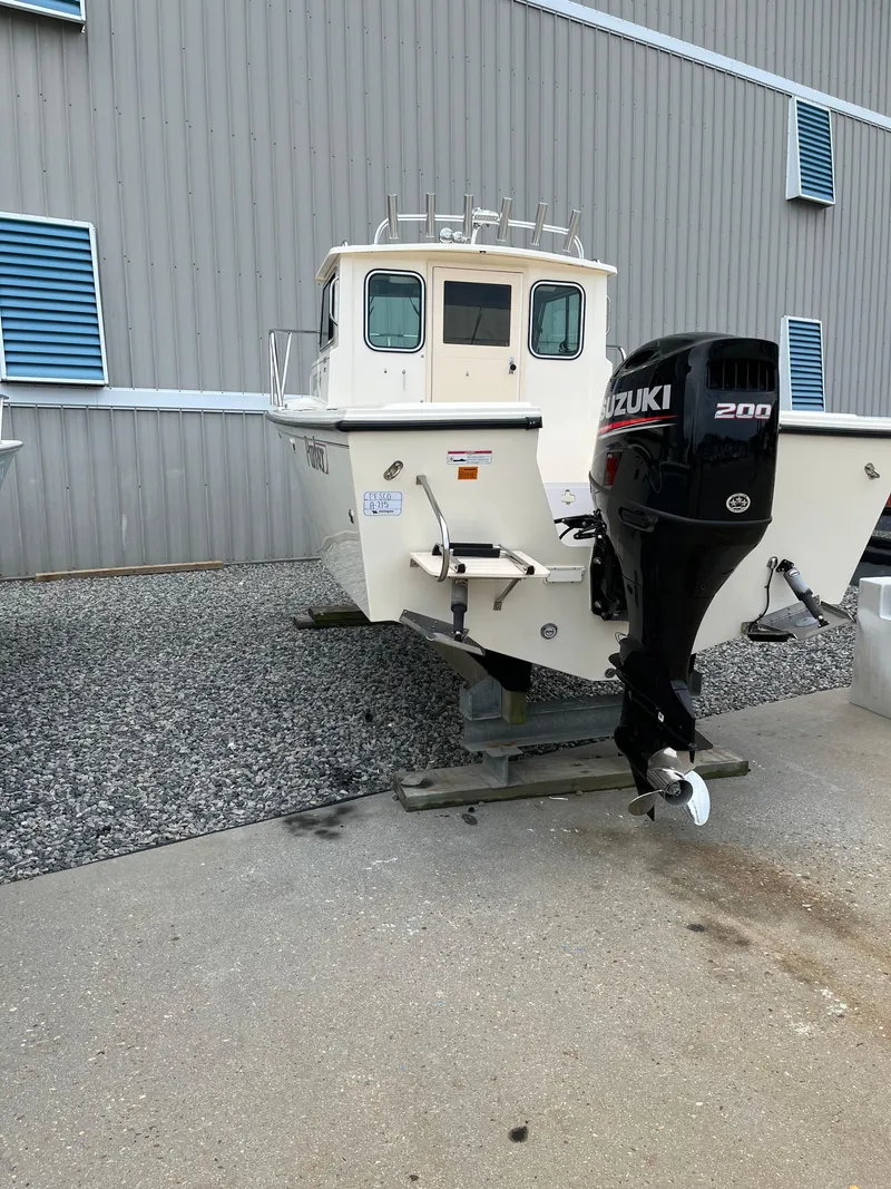 Slide: The Image of 2008 Parker 2120 Sport Cabin boat with Suzuki 200 outboard motor, displayed outdoors. - 2