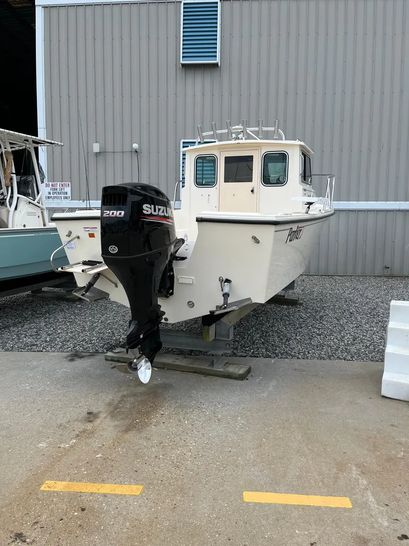 Slide: The Image of 2008 Parker 2120 Sport Cabin boat with Suzuki 200 outboard motor, docked on gravel. - 3