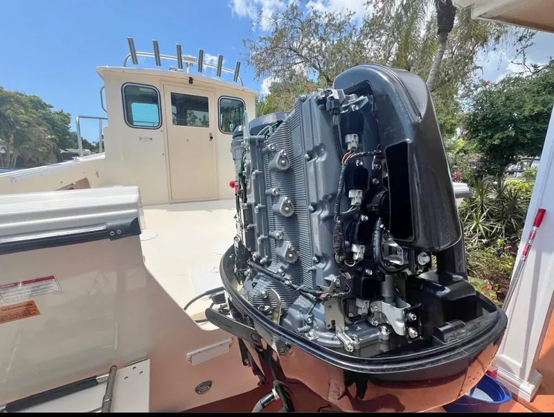 Slide: The Image of 2008 Parker 2120 Sport Cabin boat with exposed engine, docked outdoors. - 5