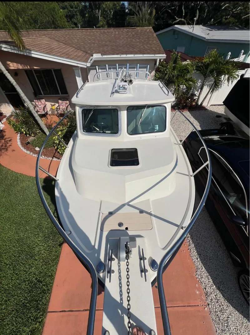 Slide: The Image of 2008 Parker 2120 Sport Cabin boat parked in a residential driveway. - 7