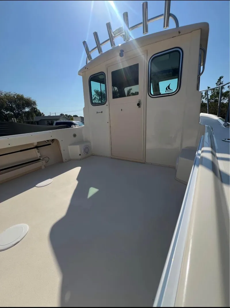 Slide: The Image of 2008 Parker 2120 Sport Cabin boat deck under clear blue sky. - 8