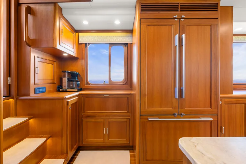 Slide: The Image of Luxurious 2023 Fleming 65 yacht kitchen with wooden cabinetry and modern appliances. - 11