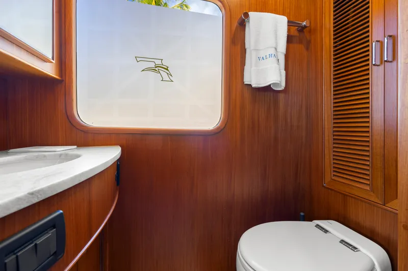 Slide: The Image of Luxurious 2023 Fleming 65 yacht bathroom with wood paneling and modern fixtures. - 17