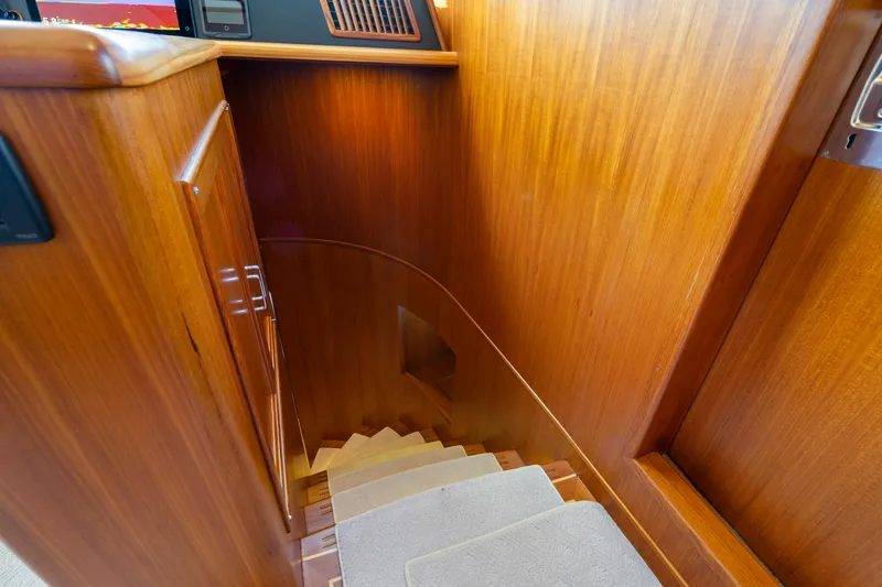 Slide: The Image of Wooden staircase inside 2023 Fleming 65 yacht, featuring elegant design and carpeted steps. - 21
