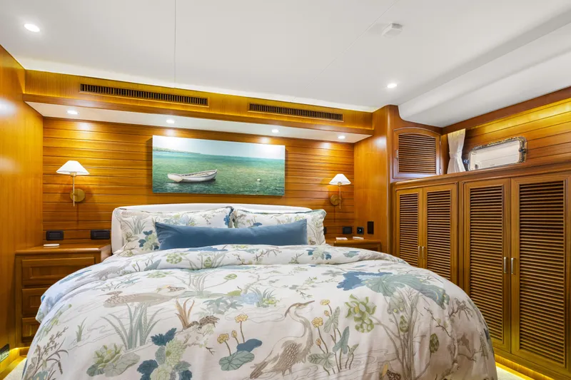 Slide: The Image of Luxurious bedroom interior on 2023 Fleming 65 yacht with wooden accents and elegant bedding. - 23