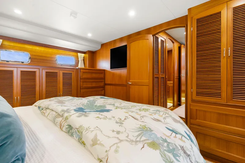 Slide: The Image of Luxurious cabin interior of 2023 Fleming 65 yacht with wooden furnishings and floral bedding. - 28