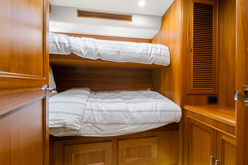 Slide: The Image of 2023 Fleming 65 yacht cabin with wooden interior and bunk beds. - 30