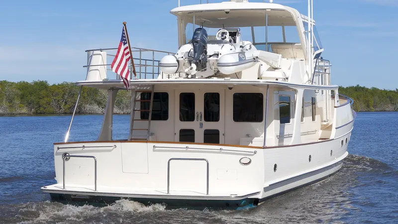 Slide: The Image of Luxury Fleming 65 yacht cruising on water, 2023 model, with American flag displayed. - 45