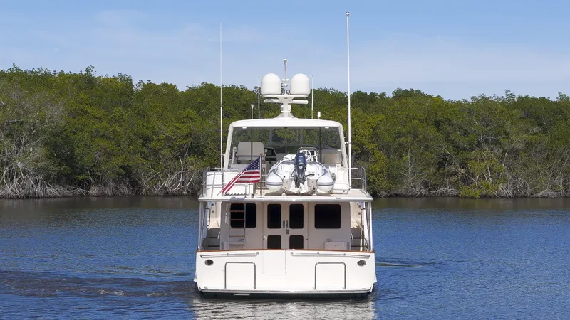 Slide: The Image of Fleming 65 yacht, 2023 model, cruising on calm water with lush greenery in the background. - 48