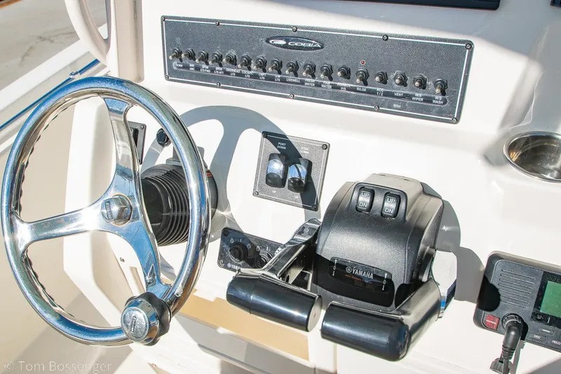 Slide: The Image of 2018 Cobia 240 CC boat dashboard with steering wheel and controls. - 18