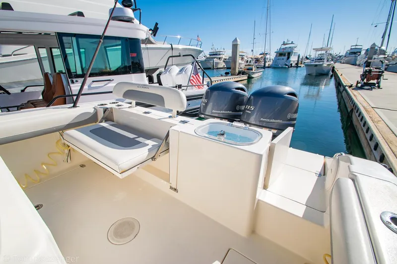 Slide: The Image of 2018 Cobia 240 CC boat with twin engines docked at a marina. - 21