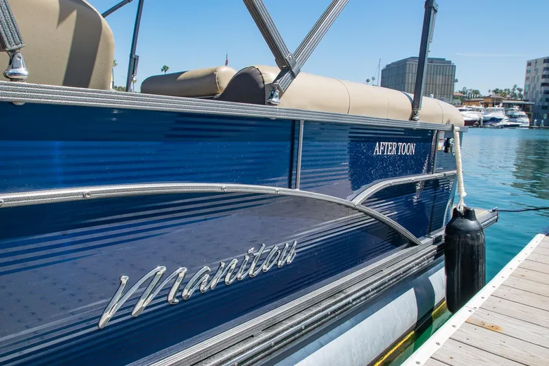 Slide: The Image of 2021 Manitou Oasis SHP pontoon boat docked at marina, blue exterior, sunny day. - 33