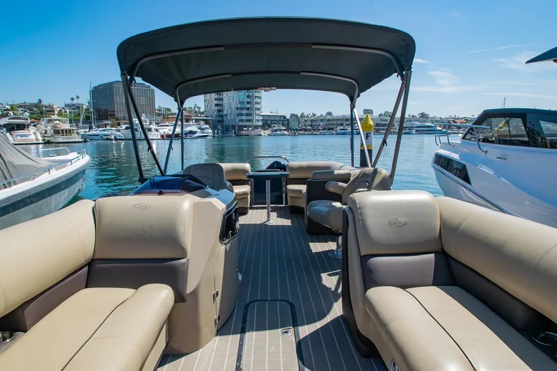 Slide: The Image of 2021 Manitou Oasis SHP pontoon boat with spacious seating, docked in a marina. - 36