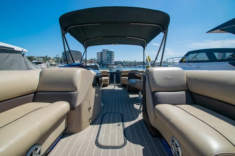 Slide: The Image of 2021 Manitou Oasis SHP pontoon boat interior with tan seating and canopy. - 42