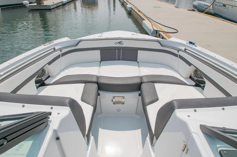 Slide: The Image of 2020 Monterey M4 boat interior with gray and white seating at a marina. - 12