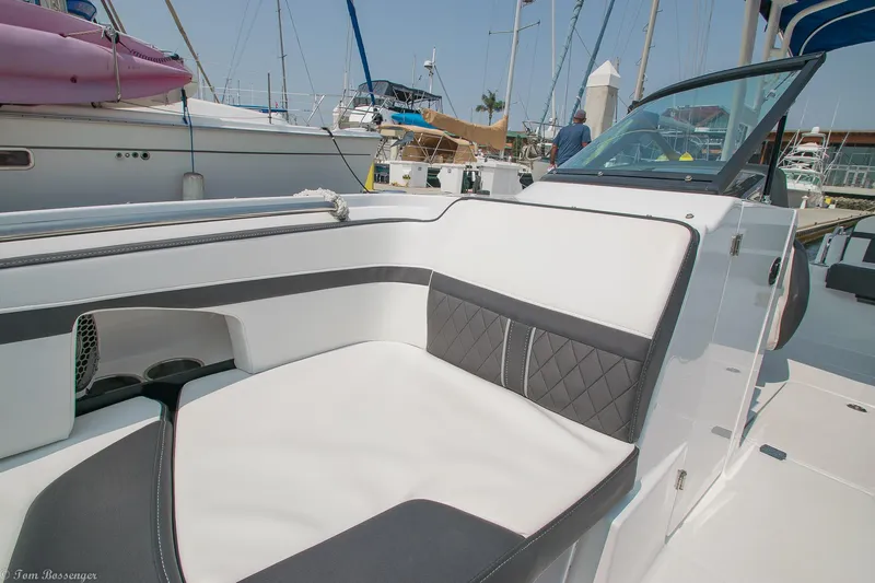 Slide: The Image of 2020 Monterey M4 boat interior with white and black seating, docked at a marina. - 14
