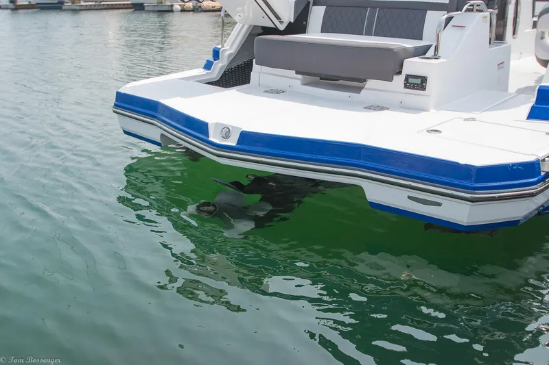 Slide: The Image of 2020 Monterey M4 boat stern in marina, featuring blue and white design. - 33