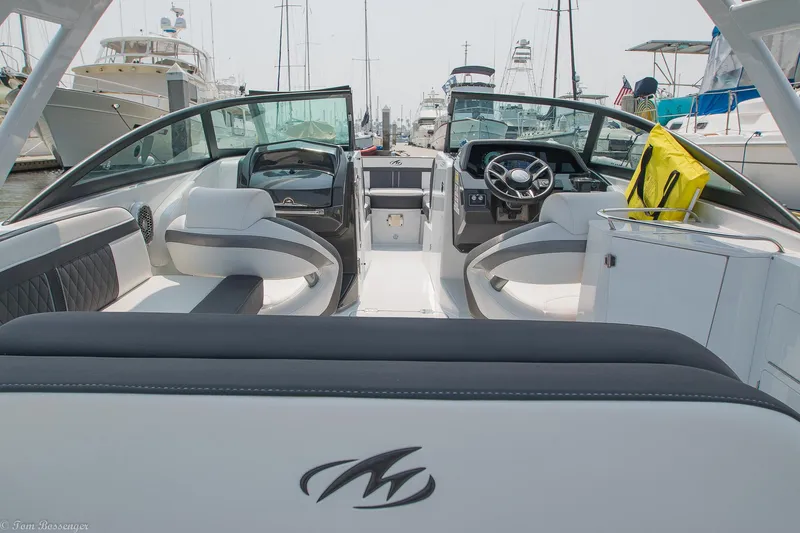 Slide: The Image of 2020 Monterey M4 boat interior with modern seating and steering, docked at a marina. - 6