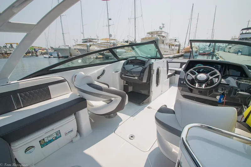Slide: The Image of 2020 Monterey M4 boat interior with steering wheel, seating, and marina background. - 8