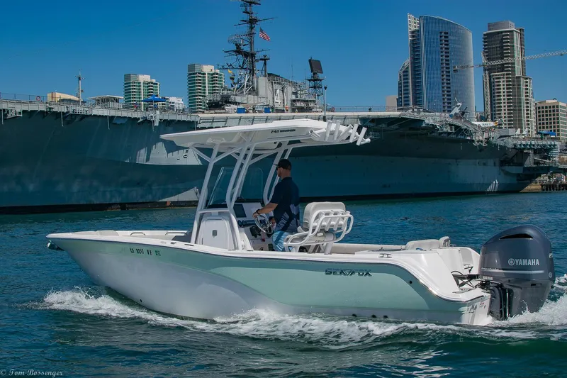 Slide: The Image of 2021 Sea Fox 248 Commander boat cruising near a large ship and city skyline. - 0