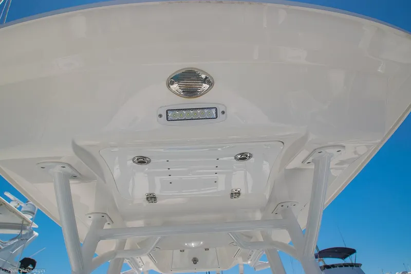 Slide: The Image of 2021 Sea Fox 248 Commander boat's T-top underside with LED lights against blue sky. - 21
