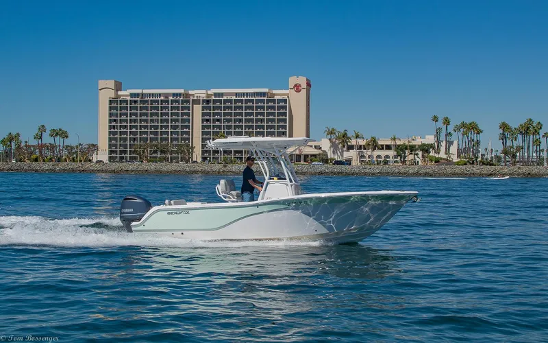 Slide: The Image of 2021 Sea Fox 248 Commander boat cruising on water near a hotel and palm trees. - 3