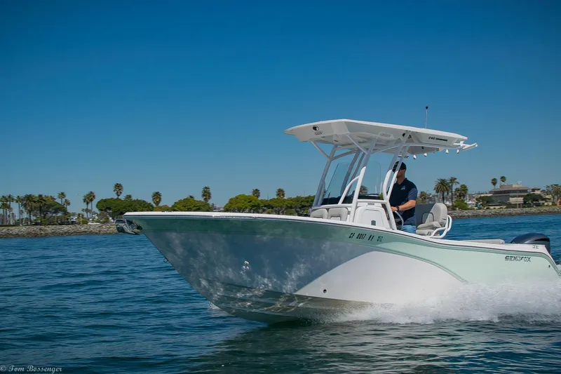 Slide: The Image of 2021 Sea Fox 248 Commander boat cruising on a sunny day, with palm trees in the background. - 36