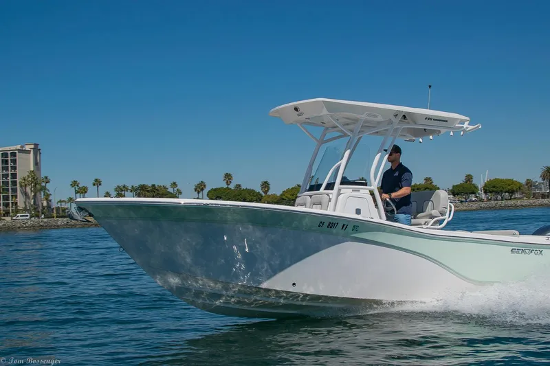 Slide: The Image of 2021 Sea Fox 248 Commander boat cruising on a sunny day, with palm trees in the background. - 37