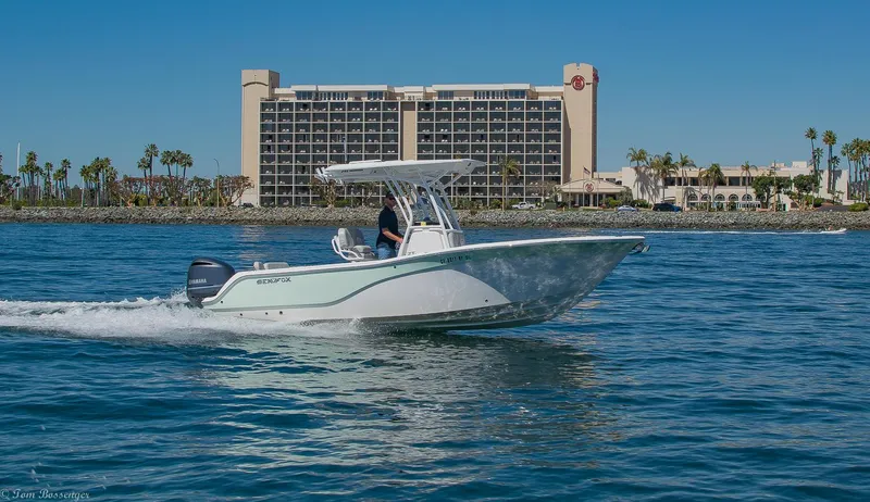 Slide: The Image of 2021 Sea Fox 248 Commander boat cruising on water near a coastal hotel. - 39