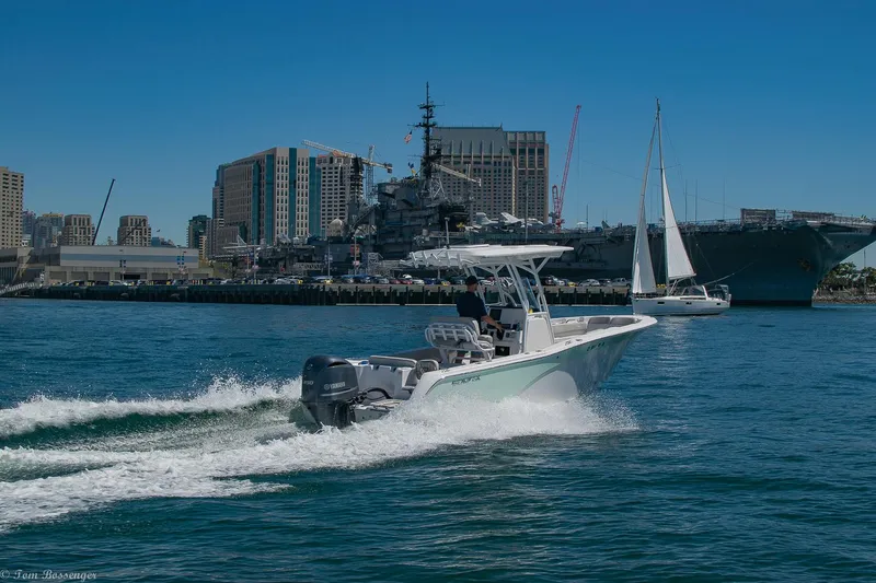 Slide: The Image of 2021 Sea Fox 248 Commander cruising in a harbor with cityscape and sailboat in the background. - 44