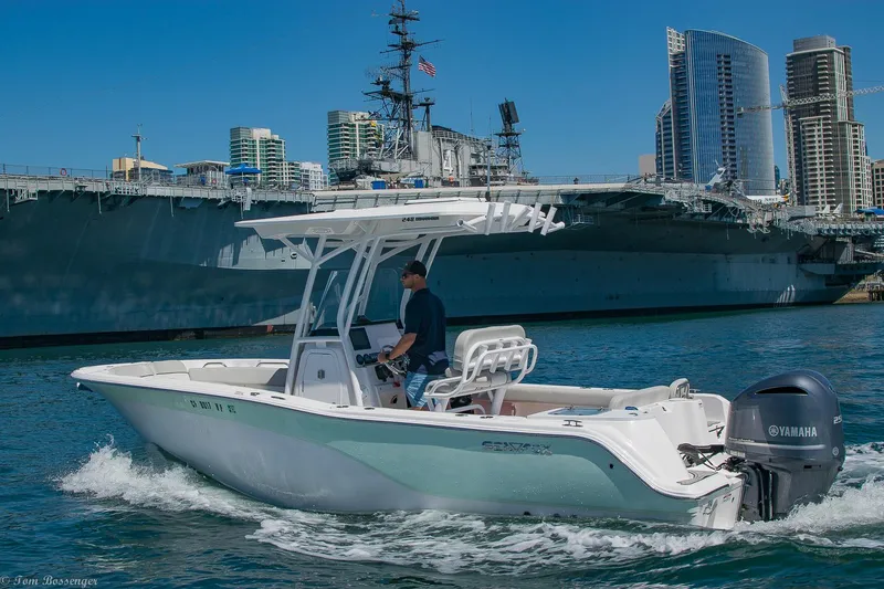 Slide: The Image of 2021 Sea Fox 248 Commander boat cruising near a large ship and city skyline. - 48