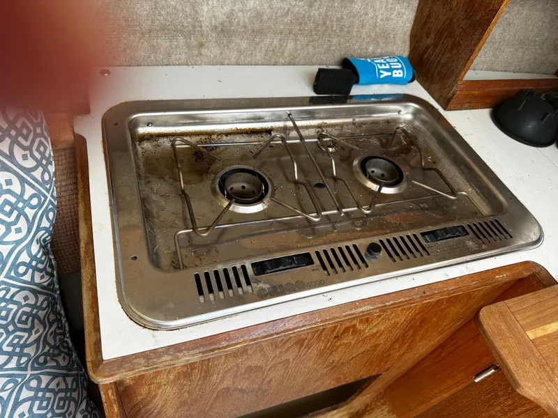 Slide: The Image of 1984 Hunter 25.5 boat stove with two burners, set in a wooden countertop. - 10