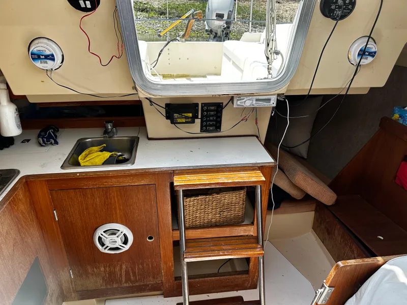 Slide: The Image of Interior of a 1984 Hunter 25.5 sailboat with kitchenette and seating area. - 11