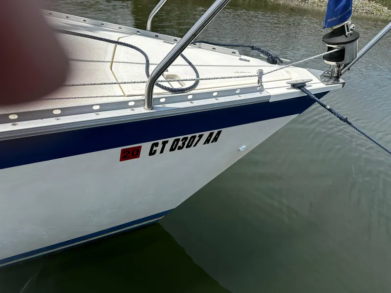 Slide: The Image of 1984 Hunter 25.5 sailboat bow with registration number CT 0307 AA on calm water. - 13