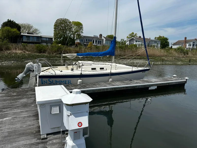 Slide: The Image of 1984 Hunter 25.5 sailboat docked, named "In Summer," with blue sail cover. - 15