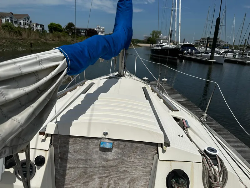 Slide: The Image of 1984 Hunter 25.5 sailboat docked at marina, mast covered, clear sky. - 3