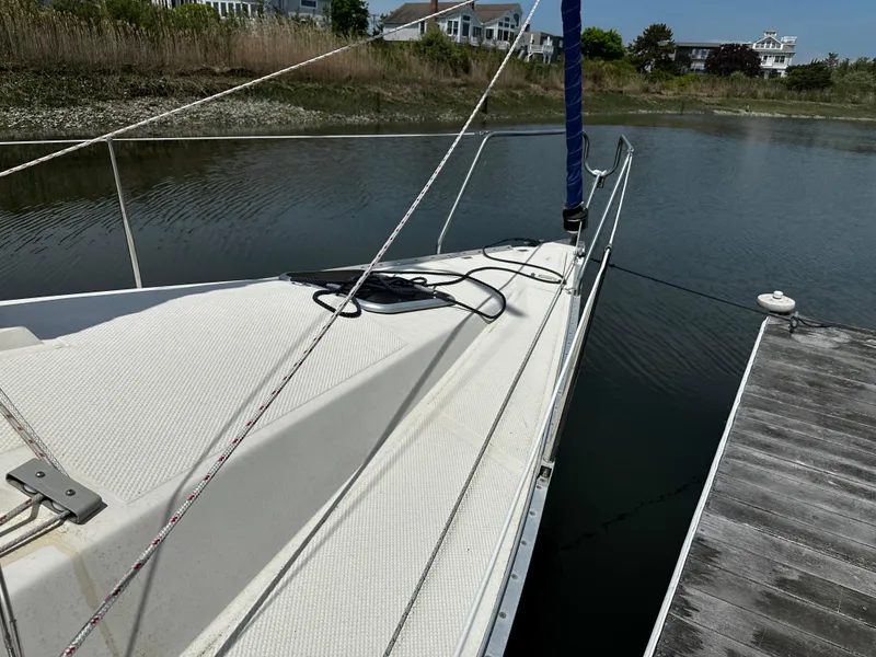 Slide: The Image of 1984 Hunter 25.5 sailboat docked in a serene marina setting. - 4