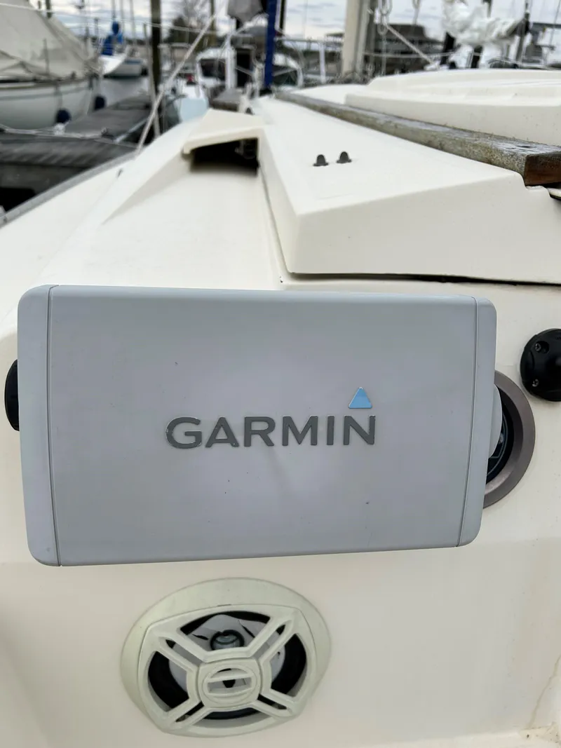Slide: The Image of Garmin device on 1984 Hunter 25.5 sailboat, docked with other boats in background. - 5