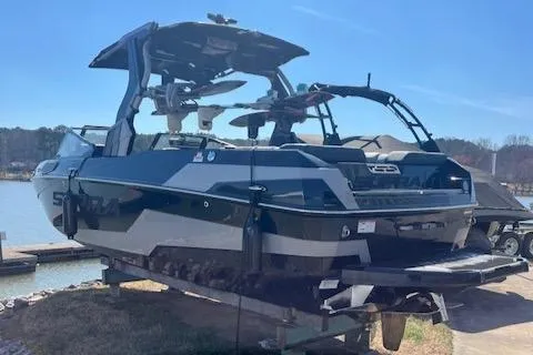 Slide: The Image of 2024 Supra SL boat docked by the lake under clear blue sky. - 1