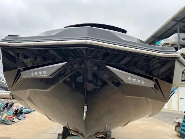 Slide: The Image of 2024 Supra SL boat, sleek black hull, docked with visible LED lights. - 14