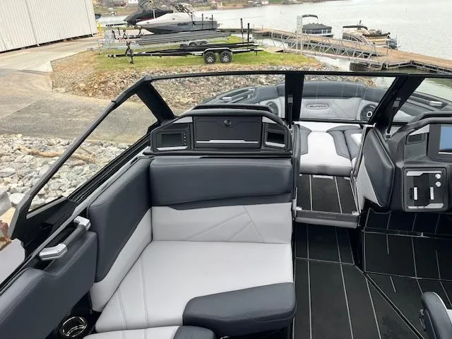 Slide: The Image of 2025 Supra SL boat interior with sleek black and white seating, dockside view. - 5