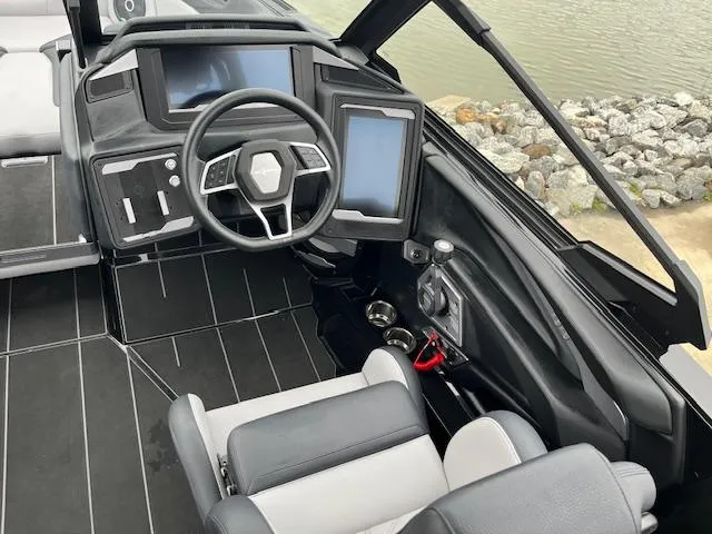 Slide: The Image of 2025 Supra SL boat cockpit with modern steering and dual screens, dockside view. - 6