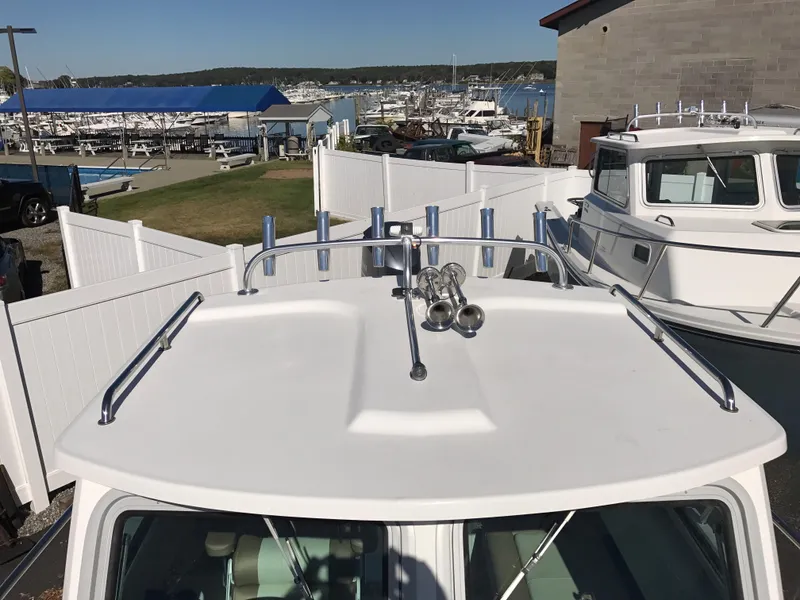 Slide: The Image of 2019 Parker 2320 SL Sport Cabin boat docked at a marina with clear sky. - 20