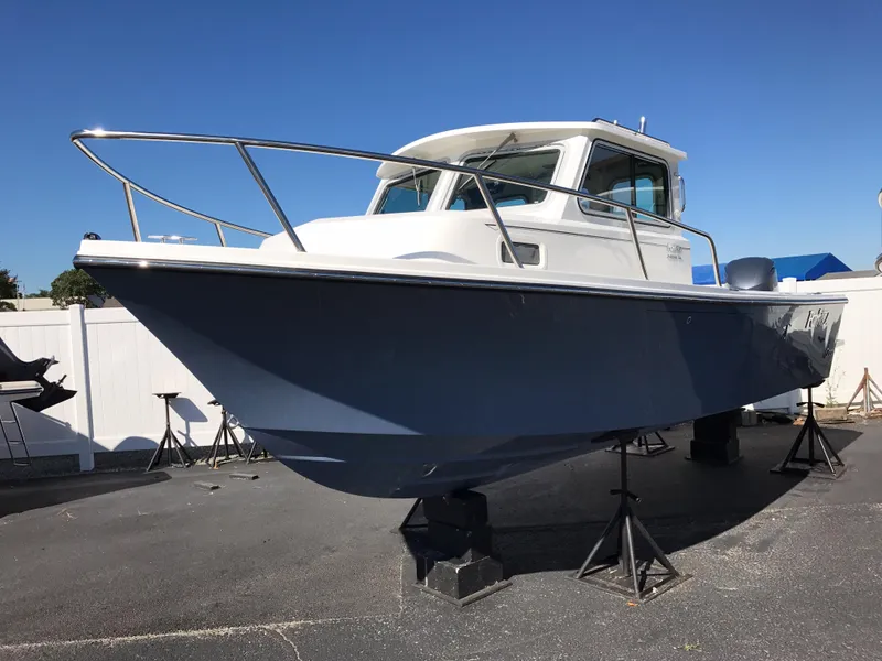 Slide: The Image of 2019 Parker 2320 SL Sport Cabin boat on stands, blue hull, white cabin. - 3