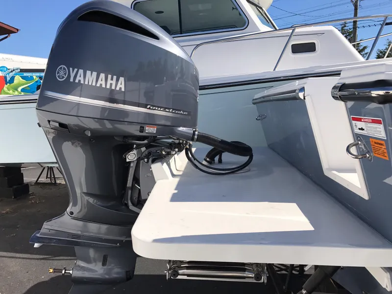 Slide: The Image of 2019 Parker 2320 SL Sport Cabin with Yamaha outboard motor, docked outdoors. - 4